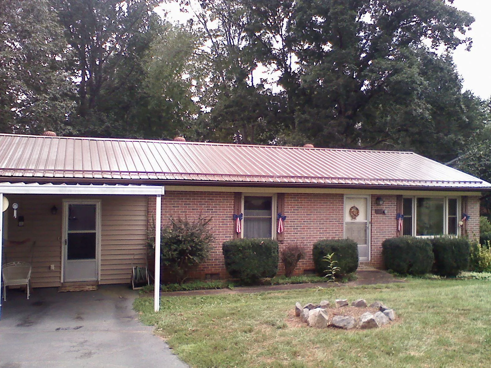 Bronze metal roof and carport on a brick ranch home — Roof Repair work by our crew in Eagle